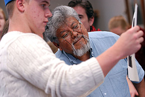 Picture of Alejandro Aranda evaluating student art.