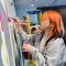 student with orange hair painting wall